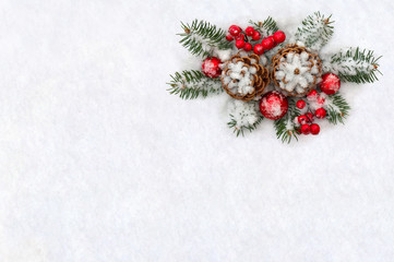 Fototapeta na wymiar Christmas decoration. Cones pine, twigs christmas tree, red balls, red berries on snow with space for text. Top view, flat lay