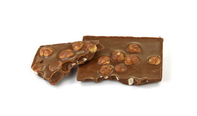 A broken piece of chocolate with hazelnuts isolated on white background. Milk chocolate tiles with nuts isolated on white.