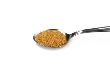 Closeup pile brown sugar in a metal spoon isolated on white background.