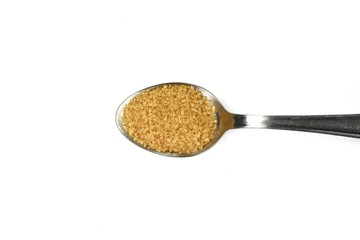 Closeup pile brown sugar in a metal spoon isolated on white background.