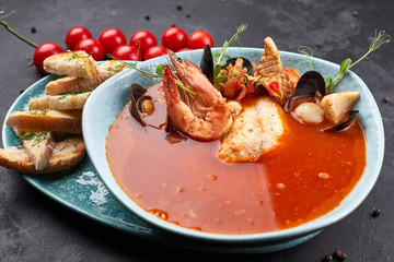 Seafood Tomato Soup, on a dark background, Bouillabaisse