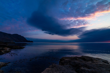 Fototapeta na wymiar Beautiful sunset in blue clouds on the seashore