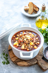 Thick minced meat soup with tomatoes, beans, chickpeas and vegetables. Healthy dinner. Copy space