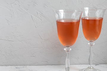 Orange wine is poured into two glasses. Celebratory drink. Family celebration.