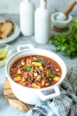 Thick minced meat soup with tomatoes, beans, chickpeas and vegetables. Healthy dinner.