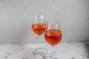 Orange wine is poured into two glasses. Celebratory drink. Family celebration.