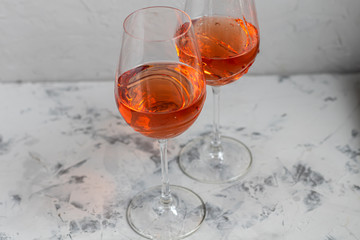 Orange wine is poured into two glasses. Celebratory drink. Family celebration.