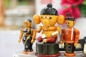 Selected Focus on Colorful Channapatna Toys of Lord God Ganesha and Man and Woman with Blurred Background