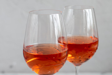 Orange wine is poured into two glasses. Celebratory drink. Family celebration.