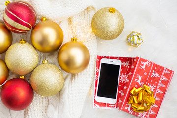Christmas balls red and gold, Christmas lights, phone as a gift for the new year, Christmas photo...