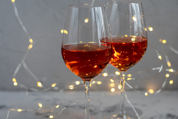 Orange wine is poured into two glasses. Celebratory drink. Family celebration.