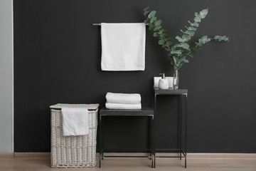 Clean soft towels on stand near black wall