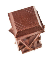 Stack of pieces of dark chocolate bar isolated on white background. Top view.