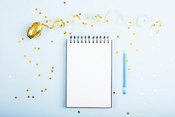 Holiday decorations and notebook on blue table. Flat lay