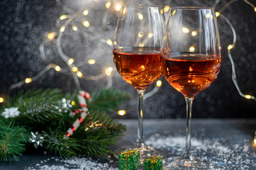 Orange wine is poured into two glasses. Celebratory drink. Family celebration.