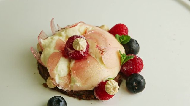 closeup focus in at broken mousse creamy dessert with berries and bize