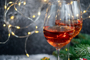 Orange wine is poured into two glasses. Celebratory drink. Family celebration.