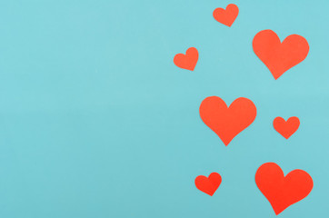 Red paper hearts on a blue background. Top view, copy space. Valentine's day, a symbol of love. Festive background
