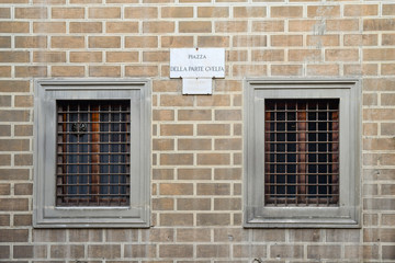 Brick wall and street sign of Guelph Party Square (Piazza della Parte Guelfa) in the historic centre of Florence, so called for the Guelph party, which in 1266 won over that Ghibelline, Tuscany, Italy