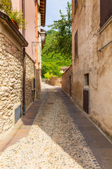 Fototapeta premium Old village street view, narrow alley, old architexcture and touristic landmark at Renzano near Salo, Italy