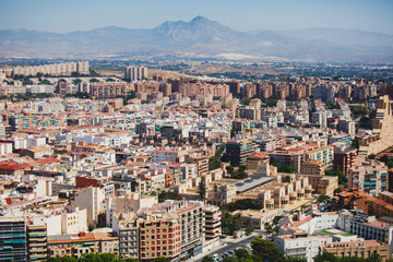 Fototapeta na wymiar Beautiful wide aerial view of Alicante, Valencian Community, Spain with port of Alicante, beach and marina, with mountains and skyline, seen from Santa Barbara Castle on Mount Benacantil, sunny day