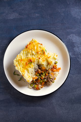 Shepherd's Pie or Cottage Pie on plate, gray backgroud. Overhead vertical image