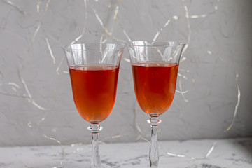 Orange wine is poured into two glasses. Celebratory drink. Family celebration.