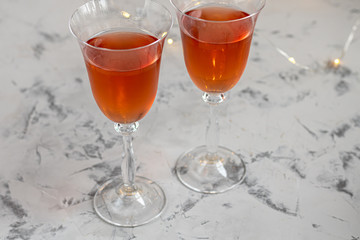 Orange wine is poured into two glasses. Celebratory drink. Family celebration.