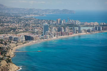Beautiful super wide-angle aerial view of Calpe, Calp, Spain with harbor and skyline, Penon de Ifach mountain, beach and scenery beyond the city, seen from Mirador Monte Toix mountain viewpoint