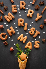 Gingerbread words Merry Christmas on dark stone background. Top view.