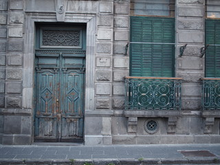 Old green painted doors in a sloping pavement