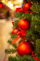 Christmas tree with silver bauble ornaments. Decorated Christmas tree closeup. Balls and illuminated garland with flashlights. New Year baubles macro photo with bokeh. Winter holiday light decoration