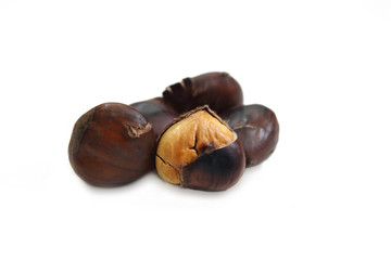 pile of cooked chestnuts with a peeled chestnut on a white background
