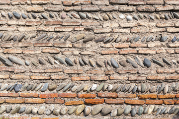 Old fortress wall built of bricks and river stones