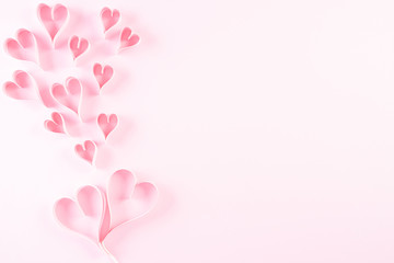 Pink paper hearts on Light pink pastel paper background. Love and Valentine's day concept.