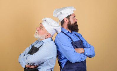 Culinary industry. Chef men wear aprons. Father and son culinary hobby. Cafe workers. Culinary show. Restaurant staff. Culinary battle. Mature bearded men professional restaurant cooks competitors