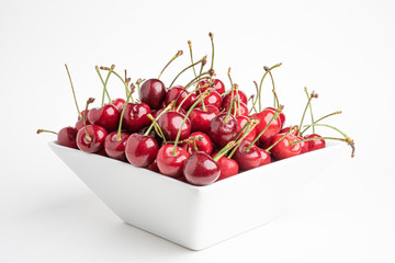 Obraz na płótnie Canvas Fresh Cherries In A Square Porcelain White Bowl