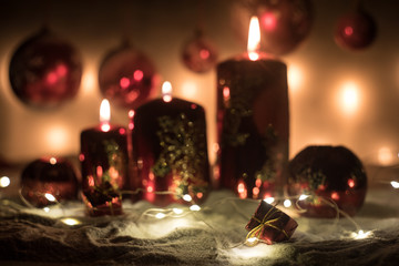 Creative artwork decoration. Christmas decoration with burning candles on a dark background. Christmas ornaments over dark golden background with lights.