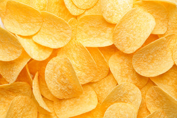 Tasty potato chips as background