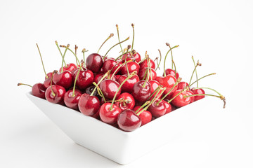 Fototapeta na wymiar Fresh Cherries In A Square Porcelain White Bowl