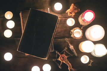 Magic book on the table in the light of burning candles. Witchcraft concept.