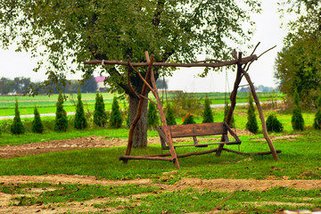 Ławka ustawiona pod drzewem  © klumb