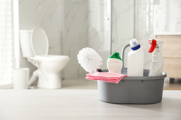 Cleaning supplies and toilet bowl in bathroom. Space for text