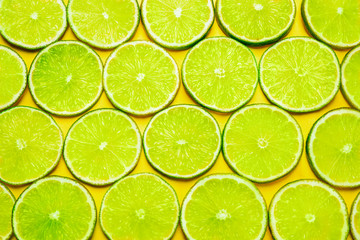 Juicy fresh lime slices on yellow background, flat lay