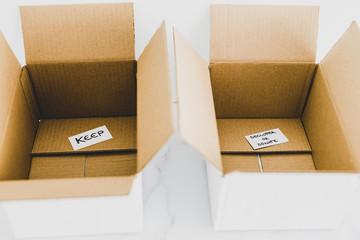 decluttering concept, storage boxes to sort between objects to keep and those to declutter or donate with labels
