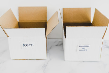 decluttering concept, storage boxes to sort between objects to keep and those to declutter or...