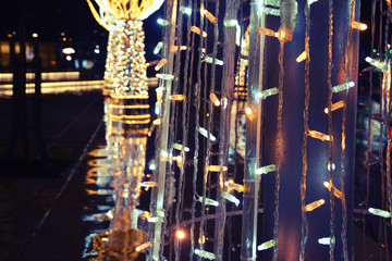 Christmas lights with reflection on the street, rainy day.