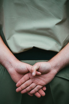 Close-up of the hands of an Australian Army soldier standing at ease during ANZAC Day remembrance ceremony