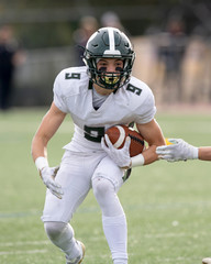Action photo of athletic football player making amazing play during a football game