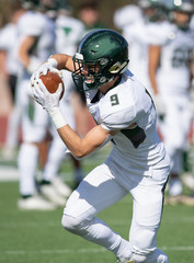 Action photo of athletic football player making amazing play during a football game